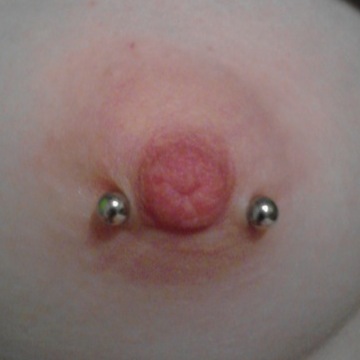 Nipple (aureola) piercing with curved bar jewelry.